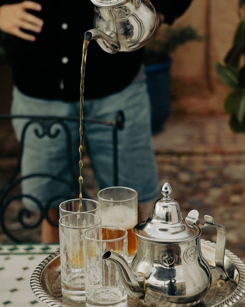 a person pouring a drink into a glass
