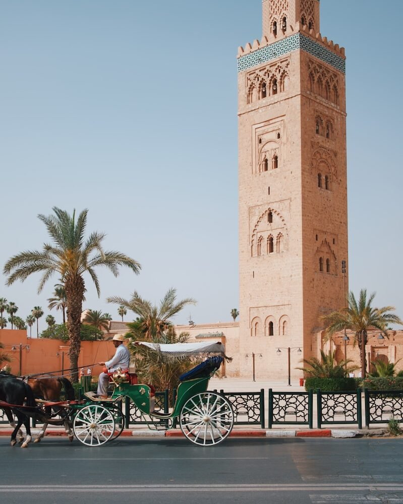 a horse drawn carriage in front of a tall tower