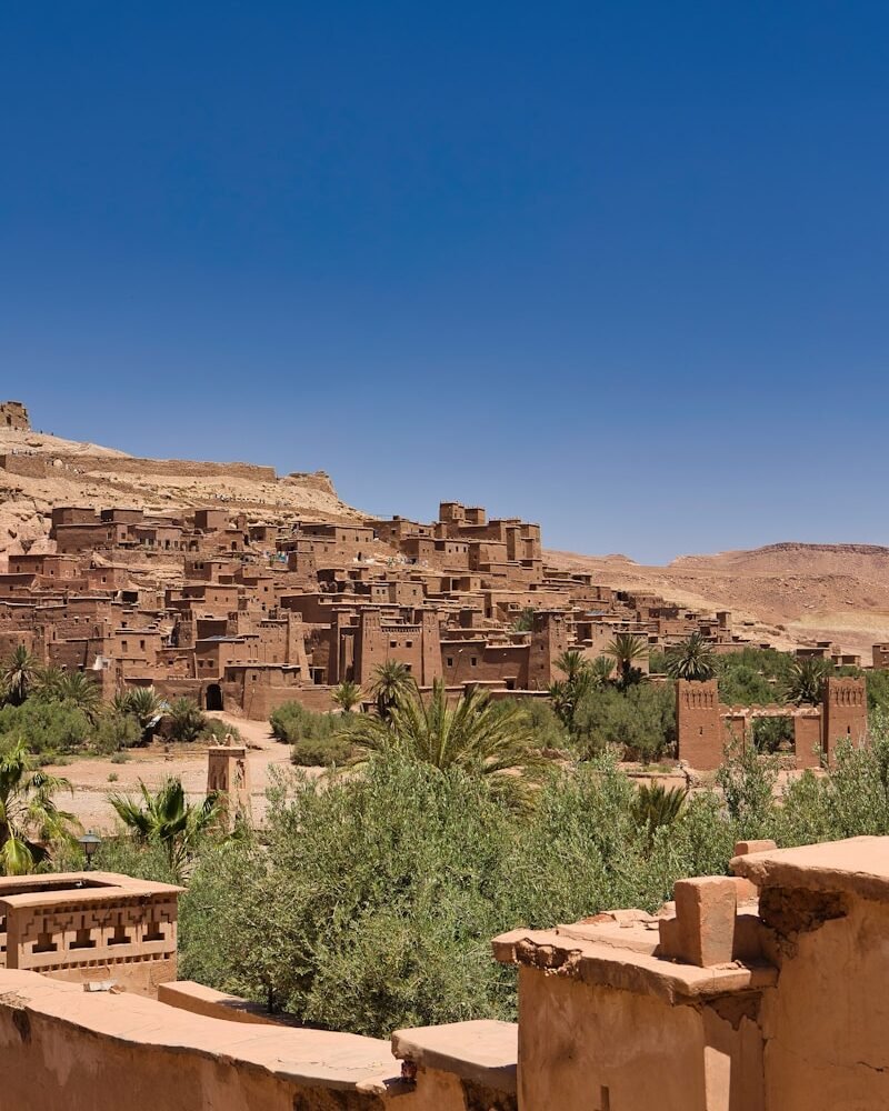 A village in the desert with a mountain in the background